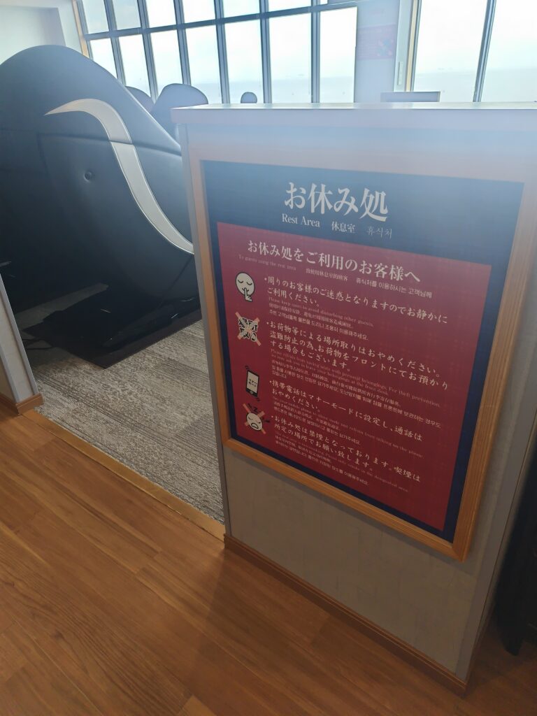 幕張温泉 湯楽の里のお休み処の案内板とリクライニングチェア