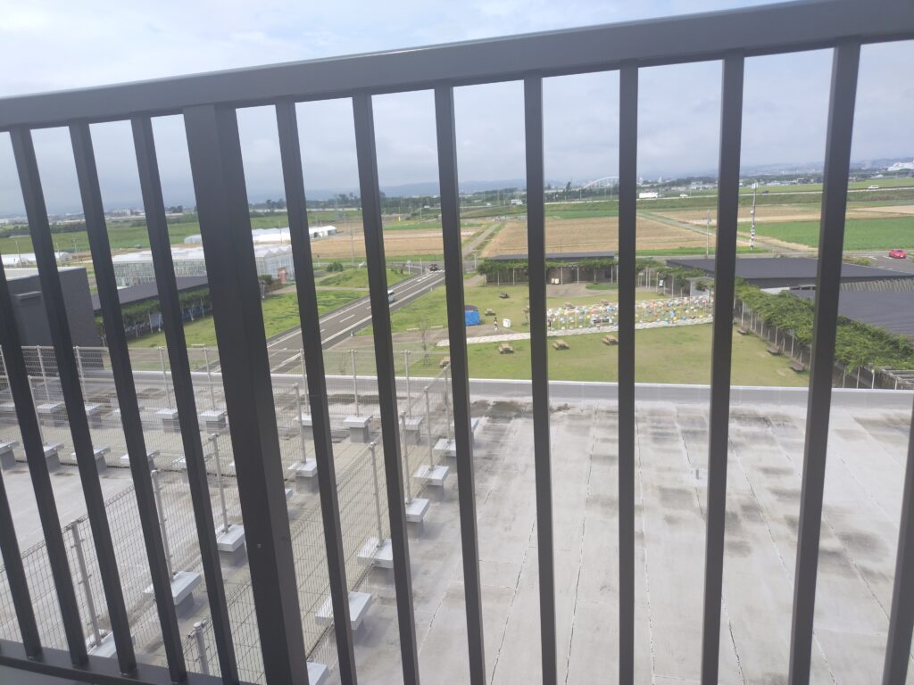 屋上展望デッキの手すりと広がる田園風景